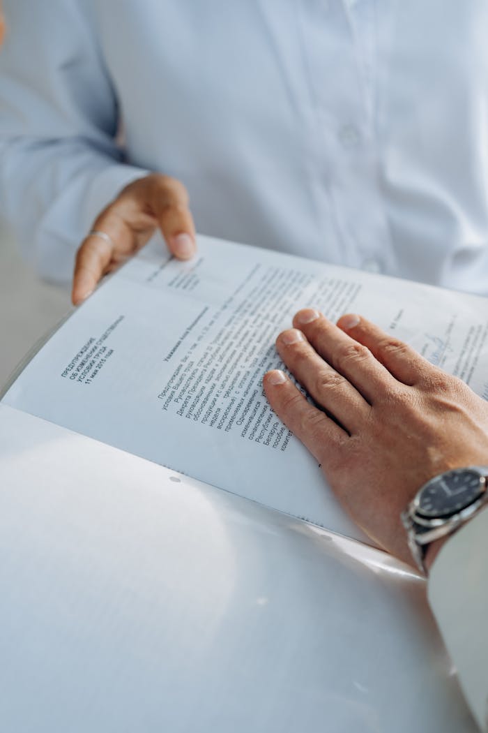 Sobre nosotros Close-up of hands reviewing a business agreement document. Professional setting.
